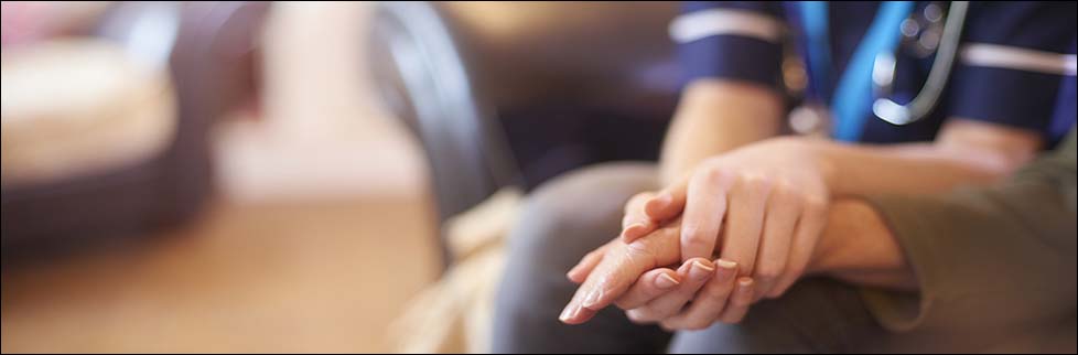 Nurse comforting patient at home