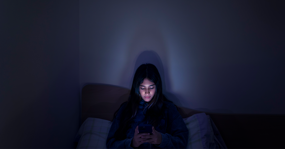 Teenage girl using a smartphone lying in bed late at night, playing games, watching videos, and typing. Children's screen addiction. Screen Addiction in Youth